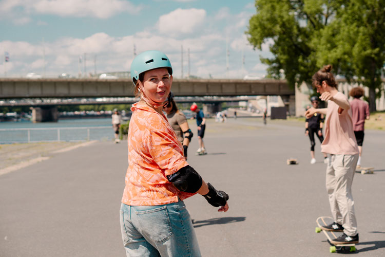 Ein Trainer zeigt den Teilnehmenden einen Dancing Step auf dem Longboard beim Longboardcamp