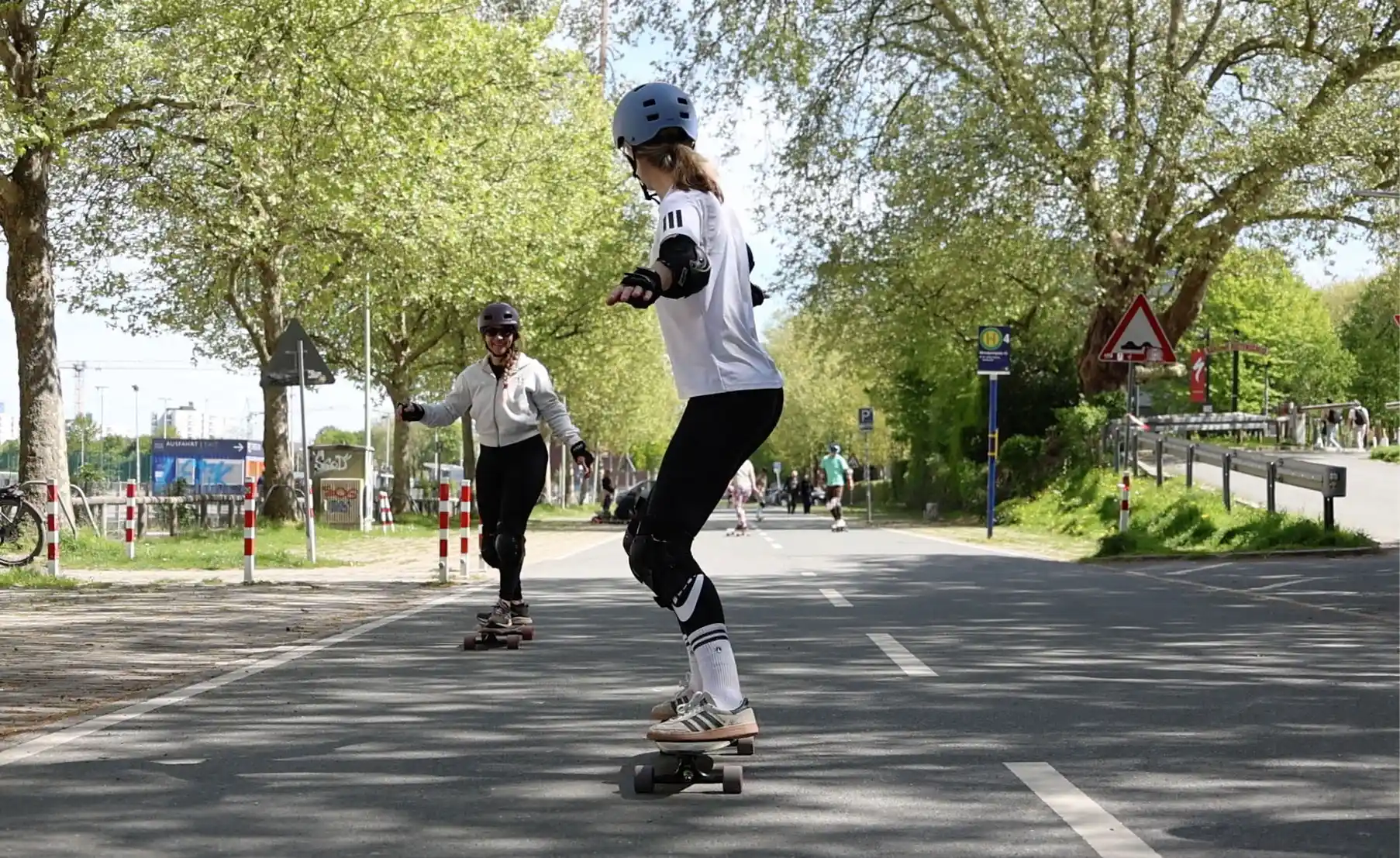Eine Frau im Longboard Kurs in Essen steht auf dem Board und fährt geradeaus